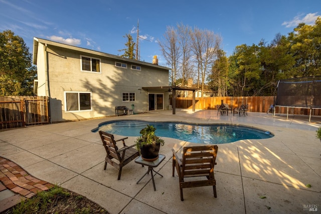 view of pool with a trampoline, a fenced in pool, a fenced backyard, and a patio