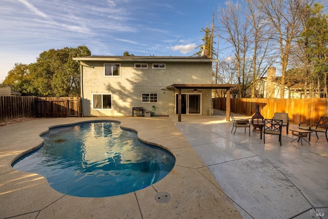 view of pool featuring a fenced in pool, a patio area, a fenced backyard, and a fire pit