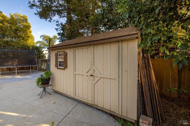 view of shed with a fenced backyard and a trampoline