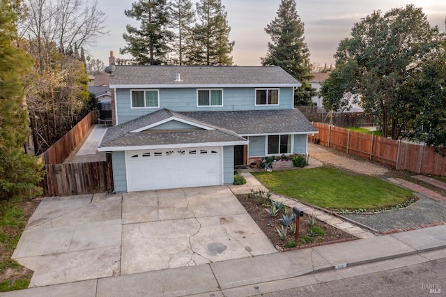 traditional-style house with roof with shingles, a yard, fence, a garage, and driveway