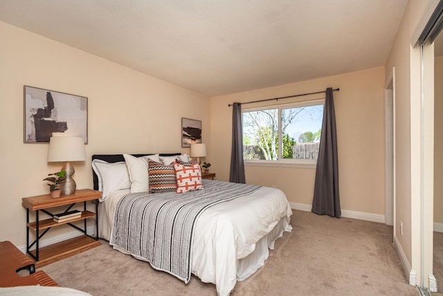 bedroom featuring light colored carpet and baseboards