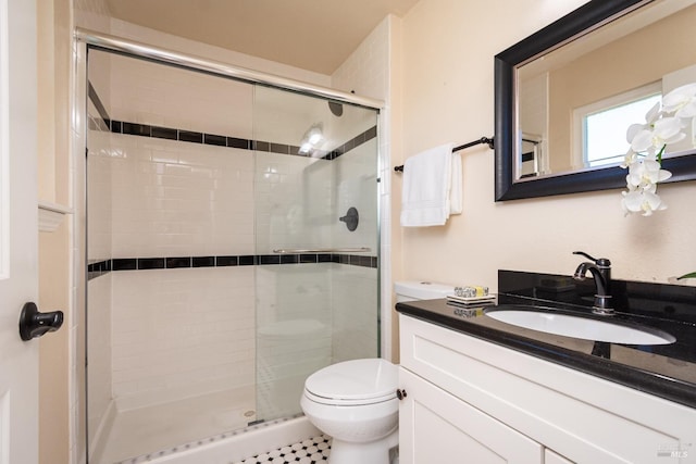 bathroom featuring a stall shower, vanity, and toilet