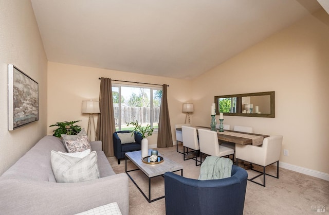 carpeted living room featuring lofted ceiling and baseboards