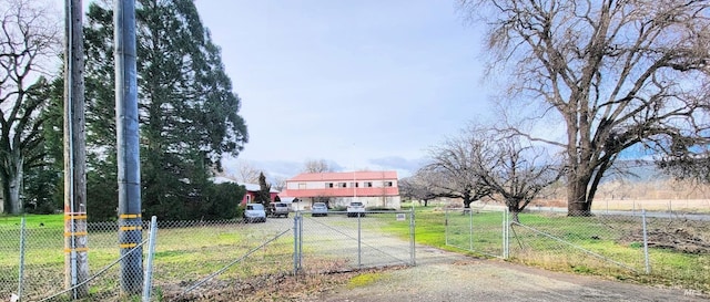 view of road featuring a gate, a rural view, driveway, and a gated entry