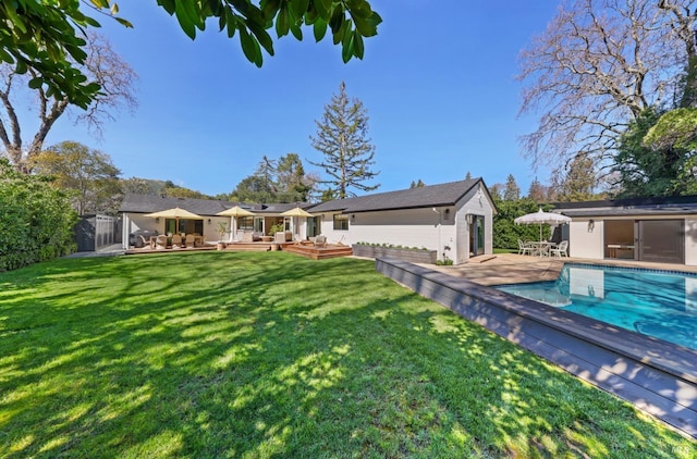 exterior space with an outbuilding, a lawn, an outdoor pool, and a wooden deck