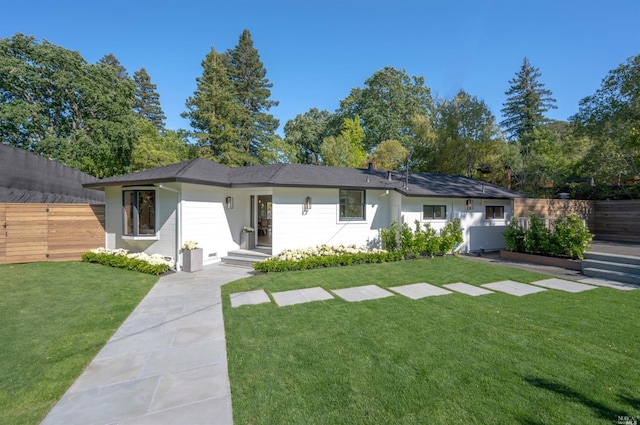 view of front facade featuring a front lawn and fence