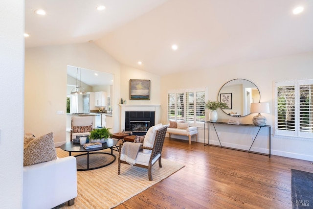 living area featuring recessed lighting, a fireplace, baseboards, and wood finished floors