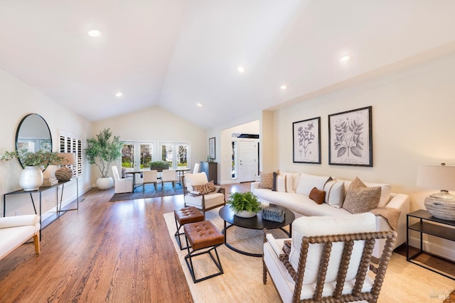 living area featuring light wood finished floors, baseboards, lofted ceiling, french doors, and recessed lighting