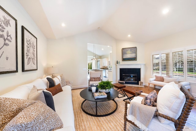 living room with baseboards, a tiled fireplace, wood finished floors, vaulted ceiling, and recessed lighting