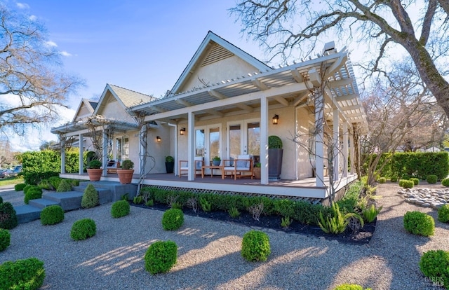 back of property featuring stucco siding, a chimney, a pergola, and french doors