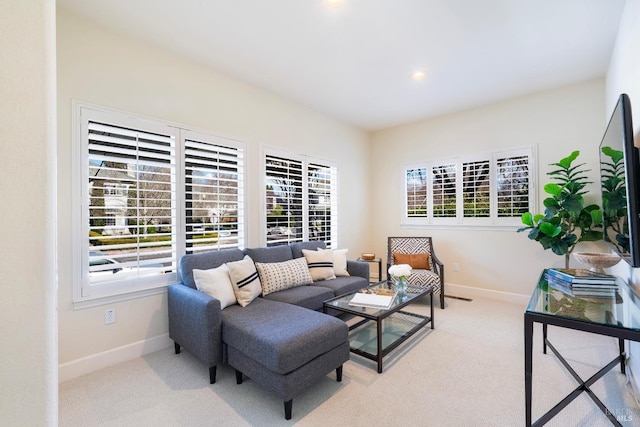 living room featuring carpet, plenty of natural light, and baseboards