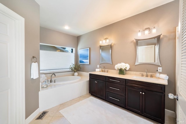 full bath with tile patterned flooring, visible vents, a sink, and a garden tub