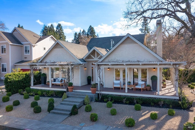 rear view of property with a pergola, outdoor lounge area, french doors, stucco siding, and a chimney