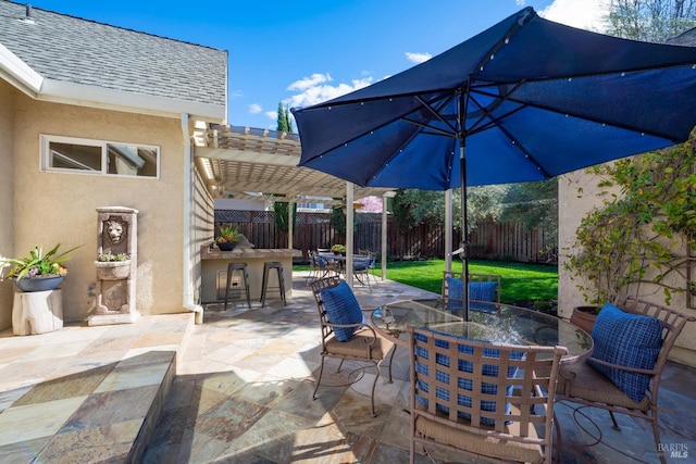 view of patio / terrace featuring outdoor dry bar, outdoor dining space, a fenced backyard, and a pergola