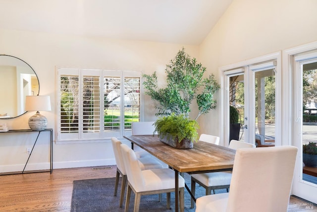 dining area with french doors, vaulted ceiling, baseboards, and wood finished floors