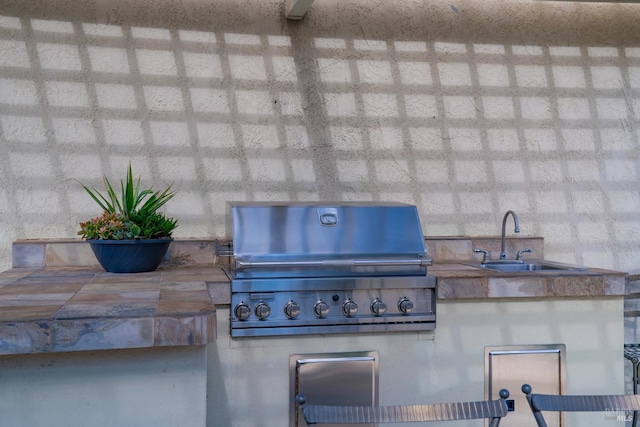 view of patio with an outdoor kitchen, grilling area, and a sink