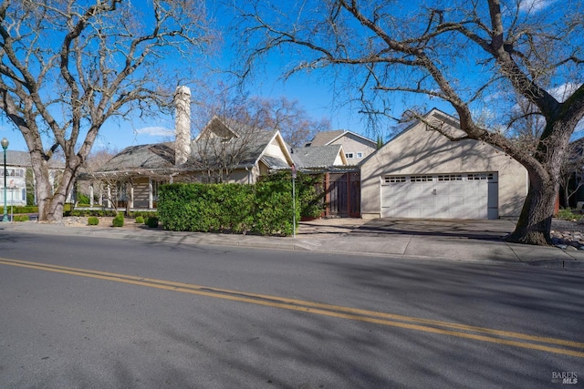 view of front facade with concrete driveway, an attached garage, and stucco siding