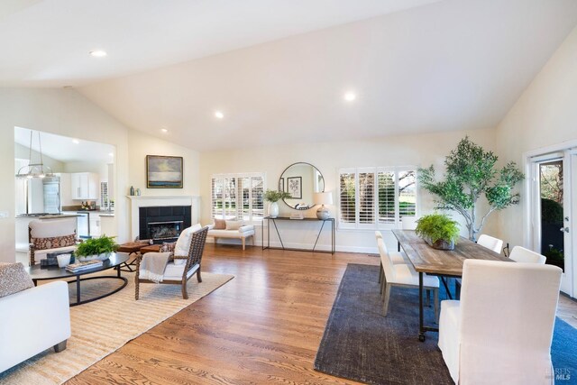 living room with a tile fireplace, recessed lighting, wood finished floors, and baseboards