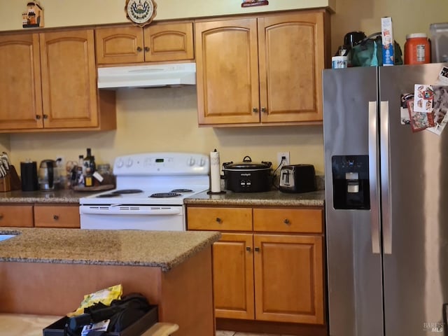 kitchen featuring white electric range, brown cabinetry, stainless steel refrigerator with ice dispenser, and under cabinet range hood