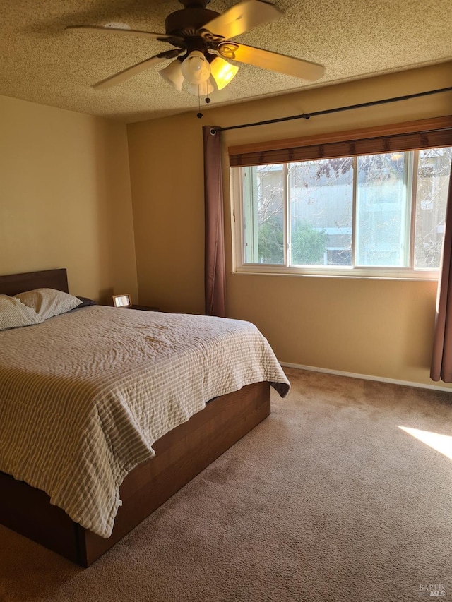 bedroom with carpet flooring, ceiling fan, a textured ceiling, and baseboards