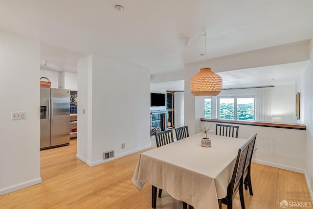 dining area featuring visible vents, baseboards, and light wood-type flooring