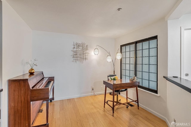 home office with baseboards and light wood-type flooring