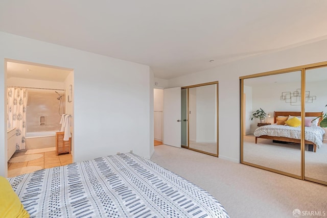 bedroom featuring two closets, light colored carpet, and connected bathroom
