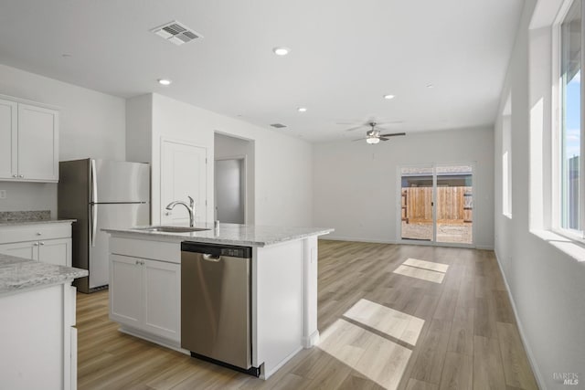 kitchen with visible vents, white cabinets, stainless steel appliances, light wood-type flooring, and a sink