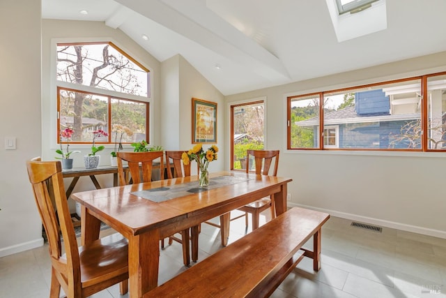 tiled dining area with high vaulted ceiling, a skylight, baseboards, visible vents, and recessed lighting