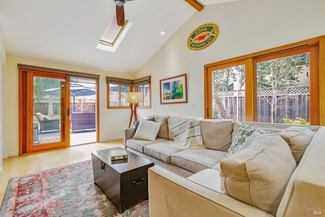 living area featuring light wood-type flooring, plenty of natural light, high vaulted ceiling, and beamed ceiling