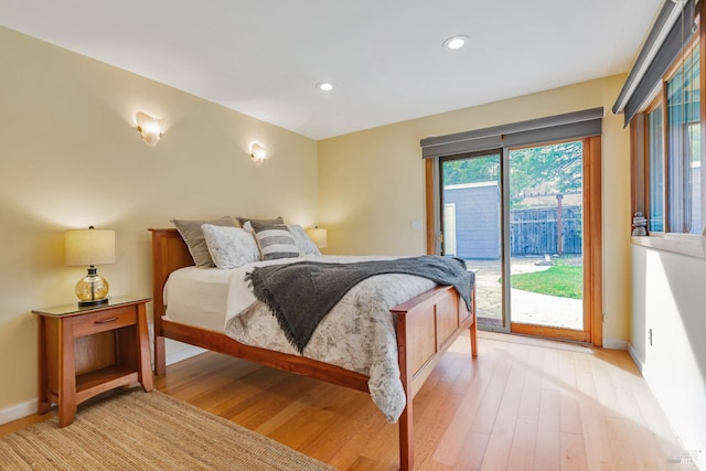 bedroom featuring baseboards, access to exterior, and light wood-style flooring