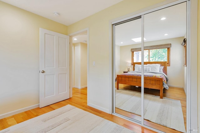 bedroom with recessed lighting, wood finished floors, a closet, and baseboards