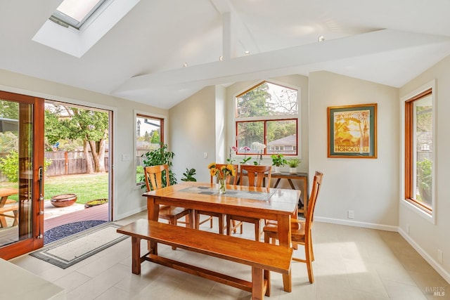 dining area featuring a skylight, baseboards, a wealth of natural light, and light tile patterned floors