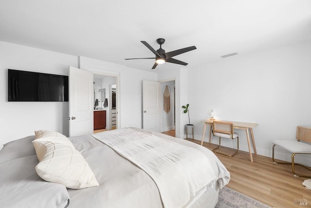 bedroom with light wood-style floors, visible vents, baseboards, and a ceiling fan