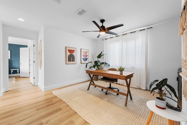 office space featuring recessed lighting, a ceiling fan, baseboards, visible vents, and light wood-style floors