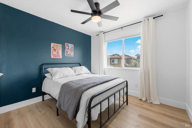 bedroom with a ceiling fan, baseboards, and wood finished floors