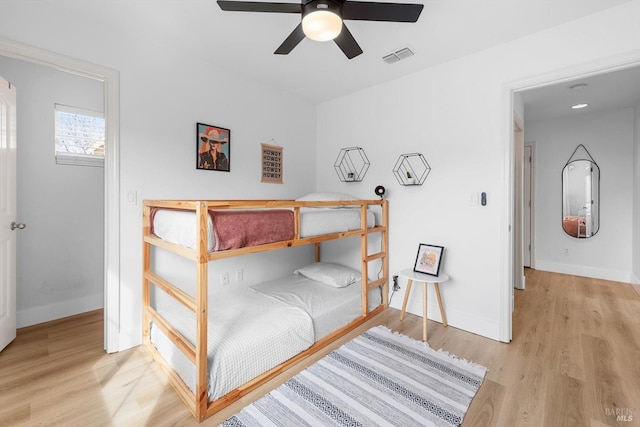 bedroom featuring ceiling fan, wood finished floors, visible vents, and baseboards