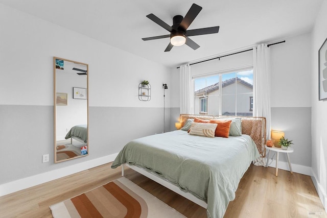 bedroom featuring ceiling fan, baseboards, and wood finished floors