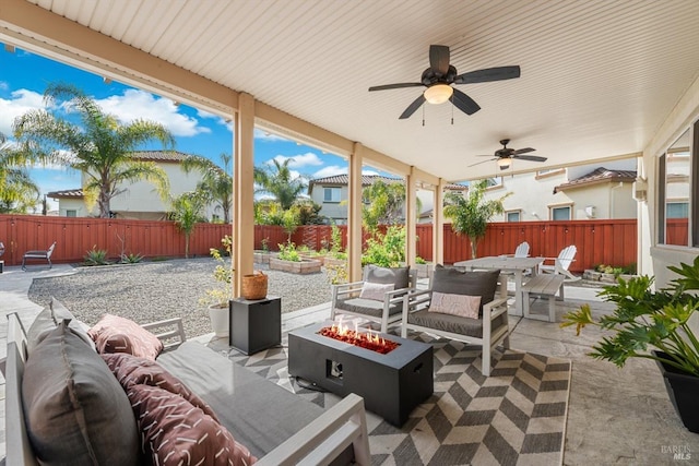 view of patio with outdoor dining area, an outdoor living space with a fire pit, and a fenced backyard