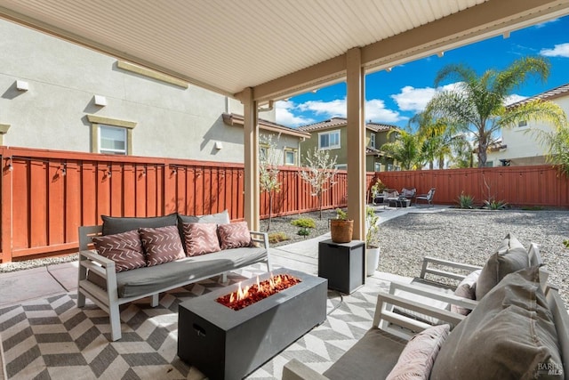 view of patio featuring a fenced backyard and an outdoor living space with a fire pit