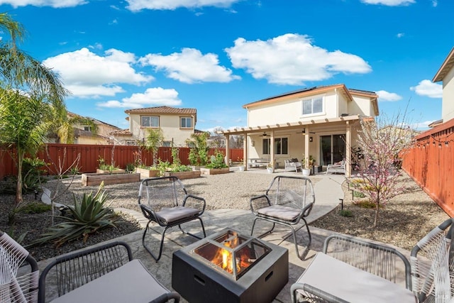 rear view of property with a vegetable garden, a ceiling fan, a patio, a fenced backyard, and stucco siding