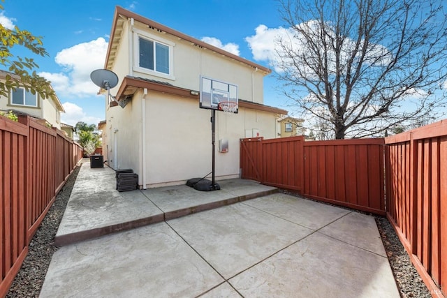 rear view of property with a patio area, a fenced backyard, and stucco siding