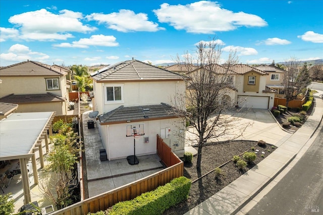 view of front of home with a residential view, a tile roof, driveway, and fence