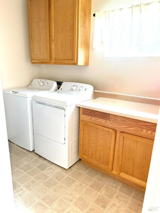 clothes washing area featuring cabinet space and independent washer and dryer