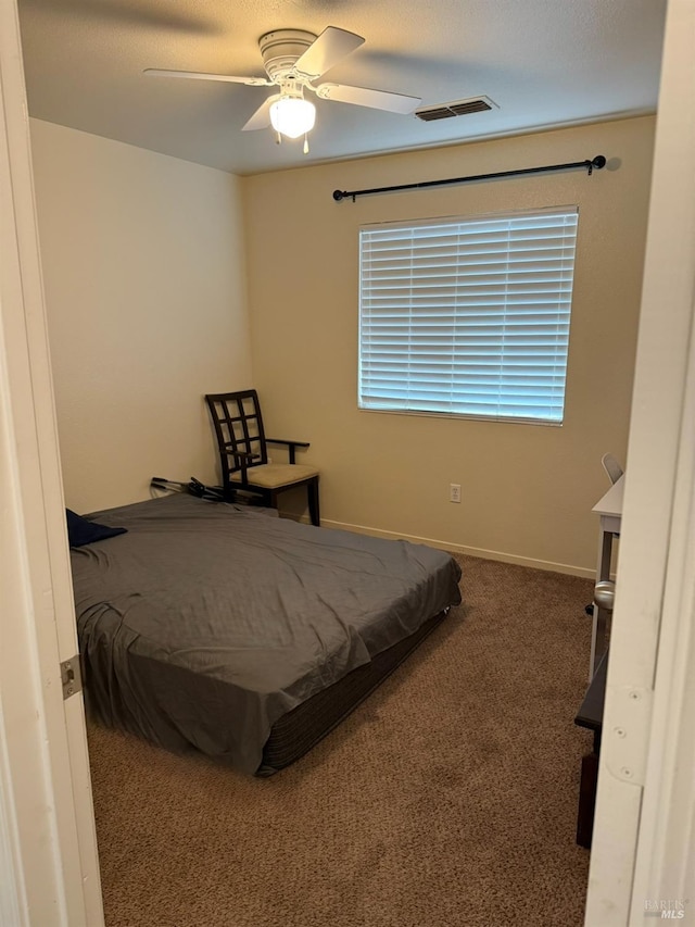 carpeted bedroom with ceiling fan, visible vents, and baseboards