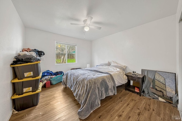 bedroom with a ceiling fan and wood finished floors