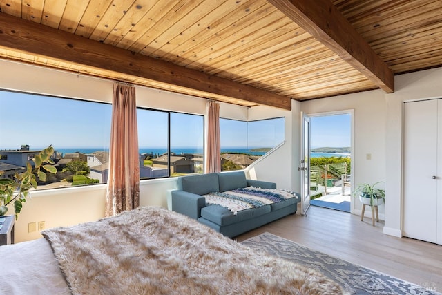 bedroom featuring beam ceiling, wood finished floors, baseboards, wood ceiling, and access to exterior