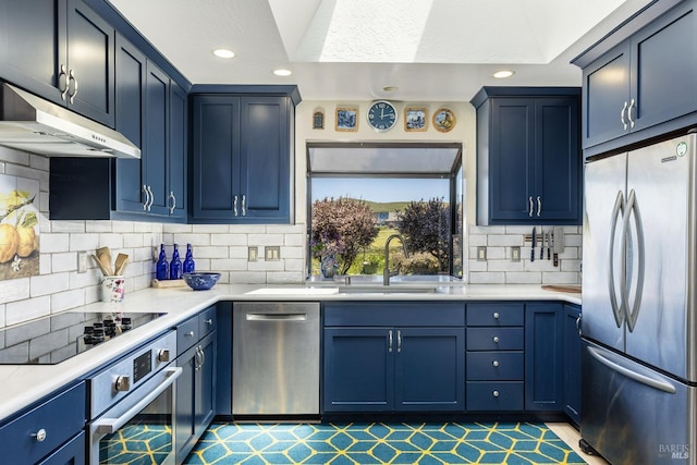 kitchen with a sink, under cabinet range hood, backsplash, stainless steel appliances, and light countertops