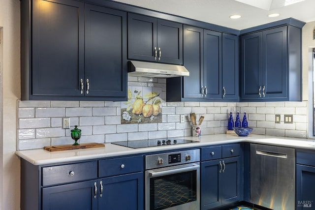 kitchen with under cabinet range hood, blue cabinetry, and appliances with stainless steel finishes