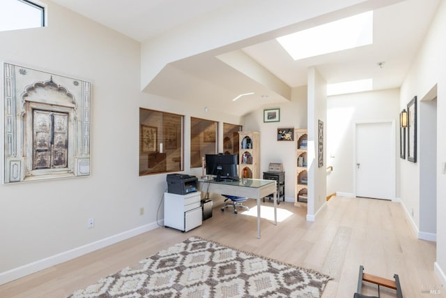 office with baseboards, wood finished floors, and a skylight